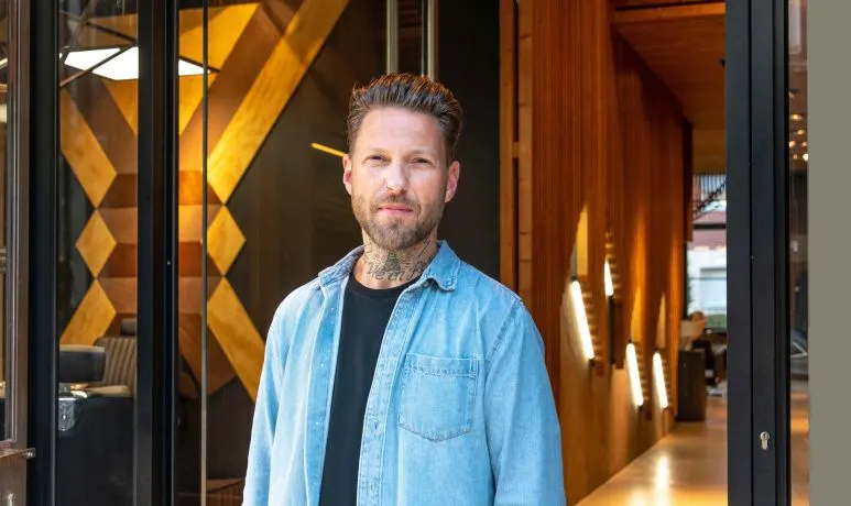 Alexis, fondateur des salons BEAU et BEL.LE, devant les lambris de bois du salon